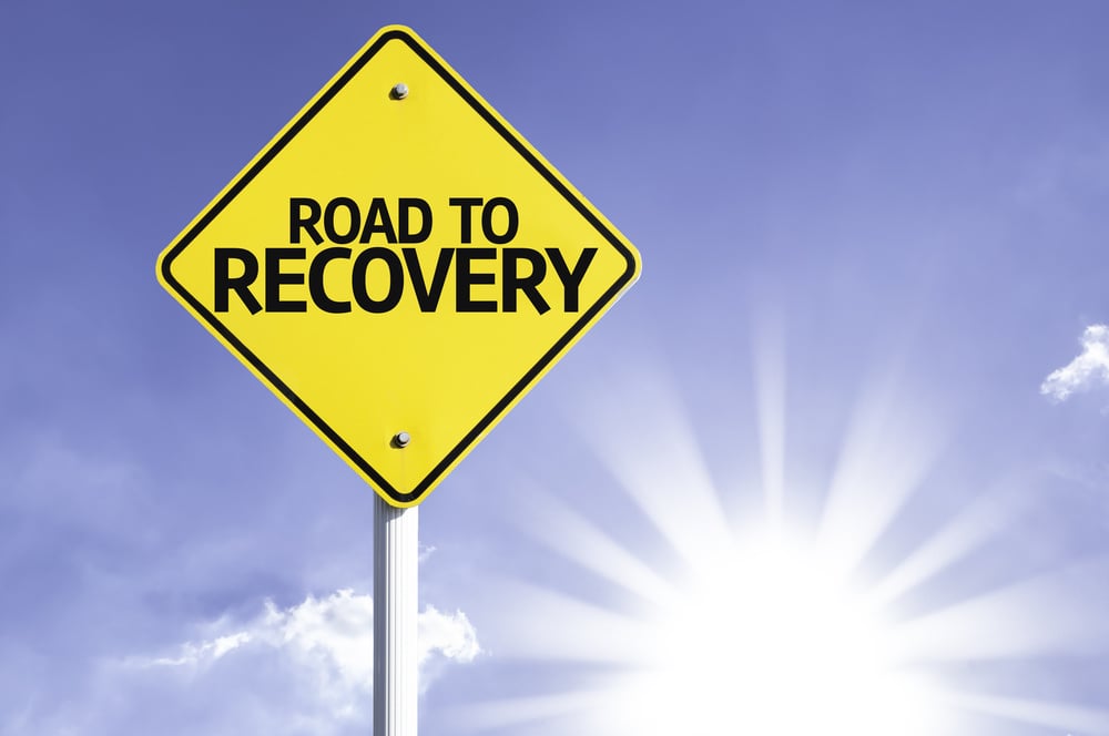 Road To Recovery road sign with sun background Road To Recovery road sign with sun background