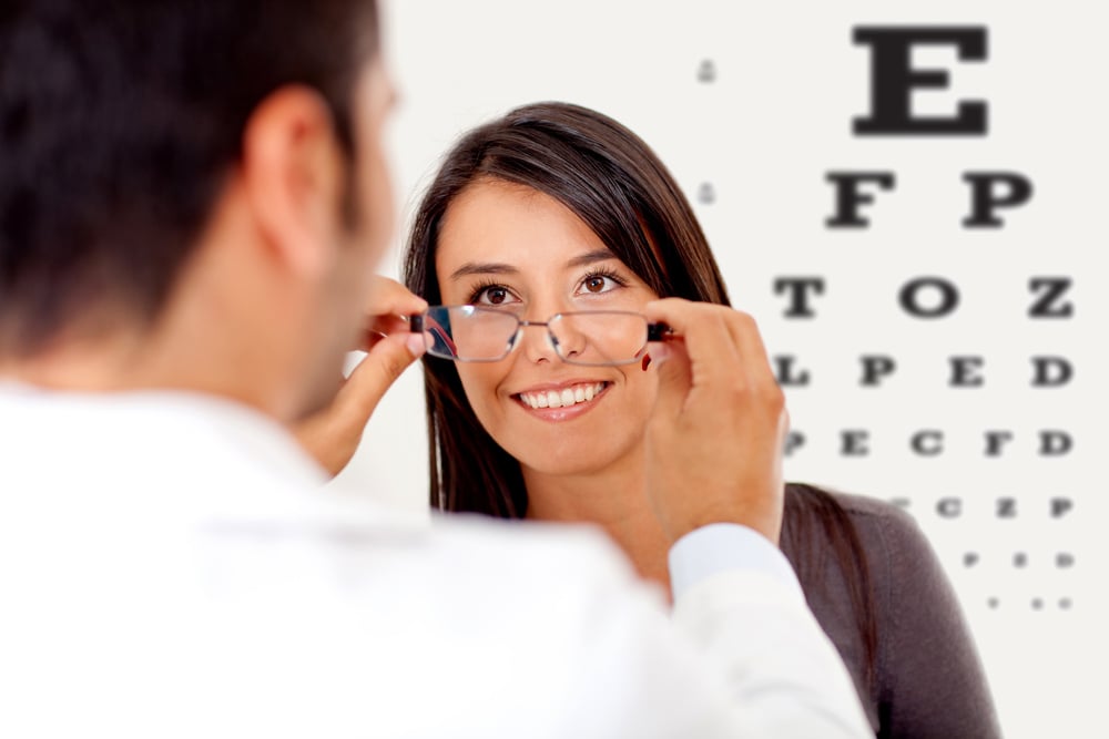Woman wearing glasses after taking a vision test at the doctor Woman wearing glasses after taking a vision test at the doctor